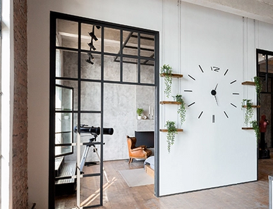 Türen im Loft-Stil mit schwarzen Metallrahmenelementen verbinden Küche und Wohnbereich.