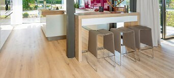 Die Küche ist mit hellem Holzlaminat ausgelegt. Eine Koch- und Essinsel mit drei Hockern lädt zum Verweilen ein.