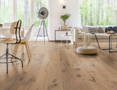 Im Wohnzimmer wurde Parkett in Langdielen-Optik verlegt. Ein Sofa und einige liebevoll platzierte Dekoelemente runden das gemütliche Ambiente ab.