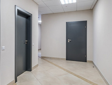 Mehrere anthrazitfarbene Wohnungstüren, Blick vom Treppenhaus.