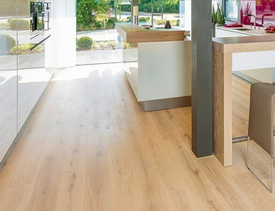 Die Küche ist mit hellem Holzlaminat ausgelegt. Eine Koch- und Essinsel mit drei Hockern lädt zum Verweilen ein.